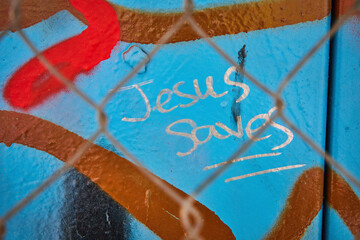 Graffiti Message of Faith Through Chain-Link Fence