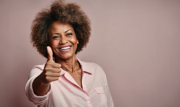 Beautiful happy afro american lady with thumb up, isolated on pink background