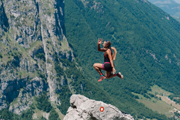 A skyrunner is jumping high and practicing in mountains.