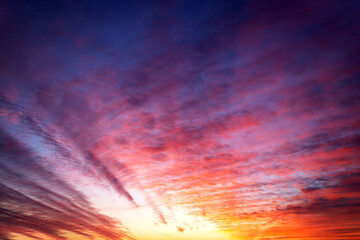 Beautiful view of the orange sky with cirrus clouds during sunset. Textured background of a beautiful sunset.