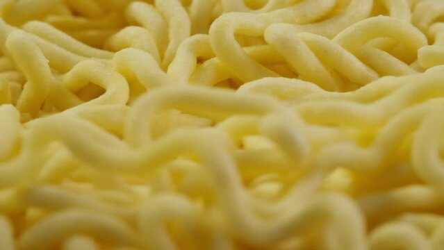 Close-up of instant noodles texture. Asian fast food with meat and spices. Instant noodles, or instant ramen, is a type of food consisting of noodles sold in a precooked and dried block with
