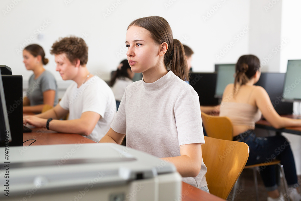 Canvas Prints Girl preparing for exam in college library, using pc for searching information