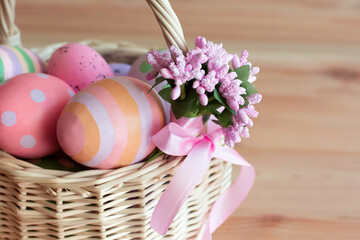 Easter eggs in a wicker basket on a wooden table with a cope space. High quality photo