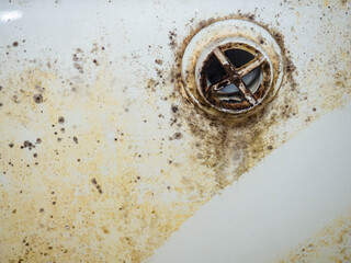 Contrast between clean and dirty. Mold and plaque on bathroom enamel. Dirt and infection. Needs cleaning. Mud cleaning concept