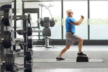 Man exercising on a step aerobic platform at a gym
