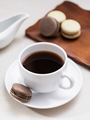 Cup of coffee and macaroons on the table on a light background