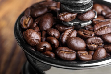 Coffee grinder with freshly roasted coffee beans close-up
