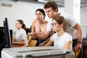 Teenage boys and girls using computers in IT room