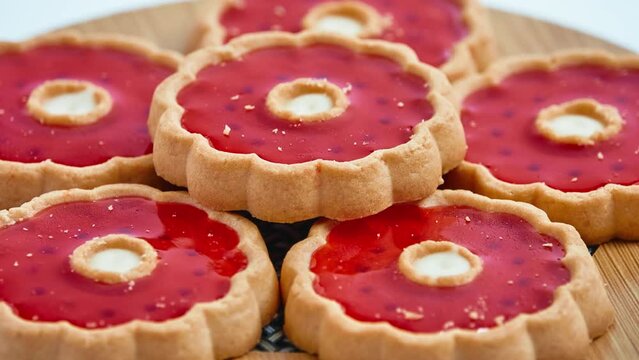 Gyration Round delicious shortbread in the form of a flower with red jelly on wooden board