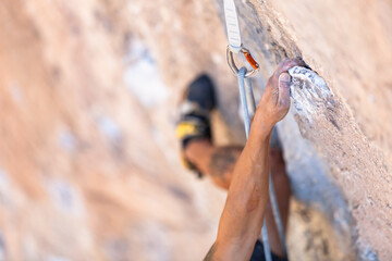 Detalle de la mano de un escalador utilizando un reposo en la roca