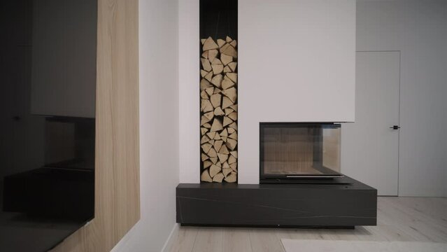 Luxurious modern design fireplace burning firewood, door with fire resistant glass window. Modern stylish fireplace and a special shelf for firewood