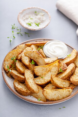 Roasted potatoes with parmesan and herbs served with creamy sauce for dipping