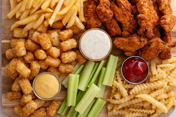 Fried chicken and french fries board with dipping sauces