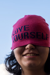 Girl wearing pink cap with self love message in sunny day