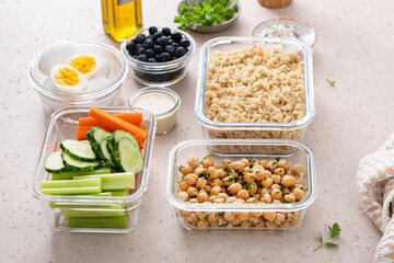 Meal prep containers with healthy food prepped, cooked quinoa, chickpeas and eggs