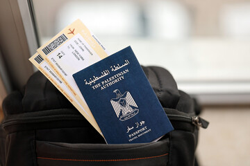 Blue Palestinian Authority passport with airline tickets on touristic backpack close up. Tourism...