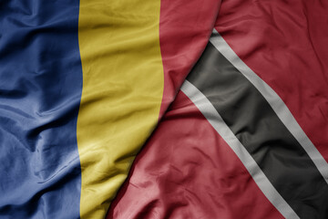 big waving national colorful flag of trinidad and tobago and national flag of romania .
