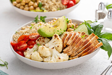 Healthy lunch bowl with high protein food, sliced grilled chicken, chickpeas and quinoa