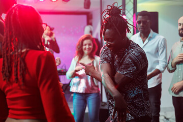 African american couple showing moves on crowded dancefloor in nightclub. Man and woman carefree...