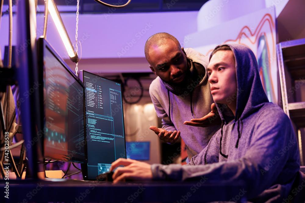 Poster hackers discussing cyberattack while checking spying online and using malware on computer. asian and