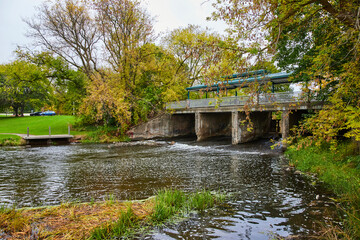Fototapeta premium Accessible Bridge over Creek in Autumn Park, Overcast Day