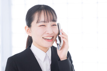 スマホで通話するビジネスウーマン　笑顔の女性