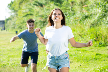 Obraz premium A couple of young people is running on the grass