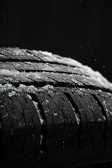 close view a tire, cover with snow, winter tires, black background
