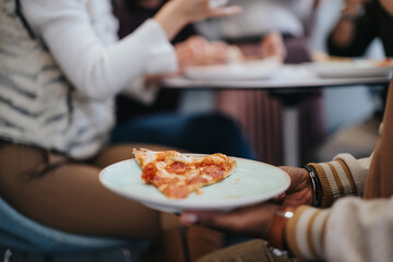 A close up photo of male person holding a plate with slice of pizza on it.