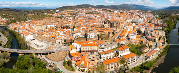 View from drone of residential area of Plasencia city with brownish tiled roofs of houses and...