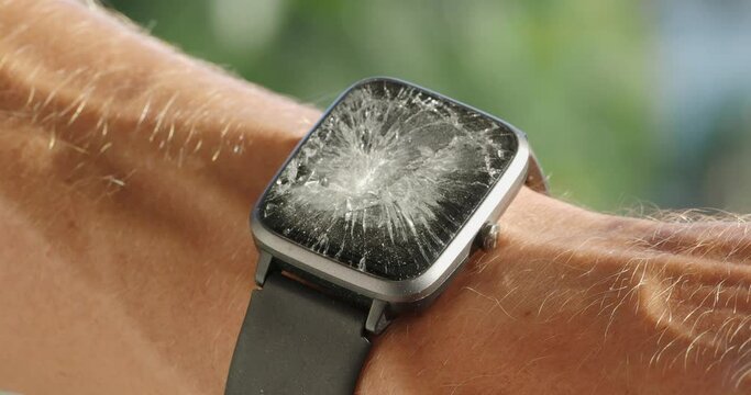 Hand with smart watch with cracked screen. Close-up.