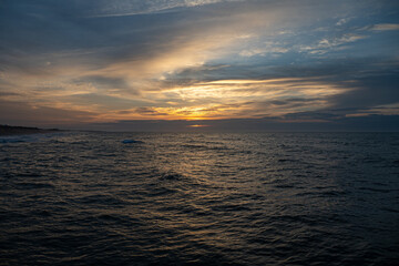 Sunrise over the ocean at Atlantic Beach, NC.  Calm ocean and a cloudy sky.