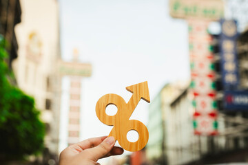 Asian businessman holding Percent sign in business with Chinatown background, concept of investing...