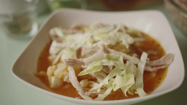 serving lettuce and radishes in red pozole