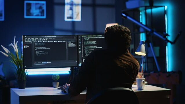 Man doing IT support job from apartment personal office drinking cup of coffee while coding. Software developer enjoying hot beverage and writing lines of code on computer, camera A