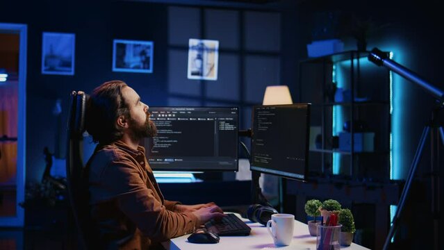 Software engineer doing programming using augmented reality visualization during remote job shift in home office. IT admin working on computer, looking at AR hologram, camera B