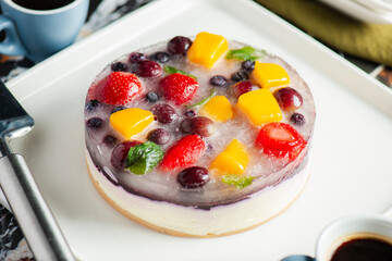Delicious and light no-bake cheesecake with summer fruits including strawberry, mango, and grapes.