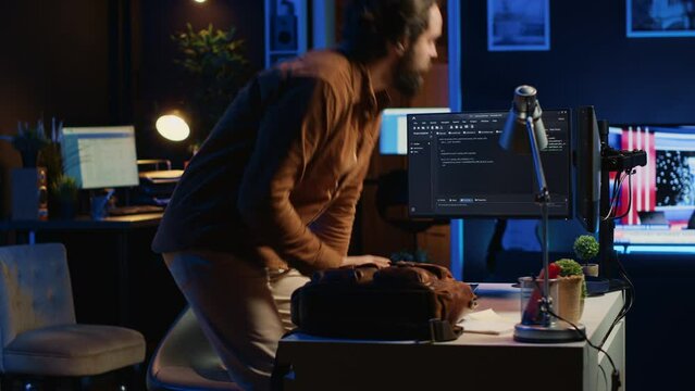 Freelancing system administrator arriving in personal office at home, resuming work on coding. IT expert starting job in apartment, writing lines of code on computer, camera A