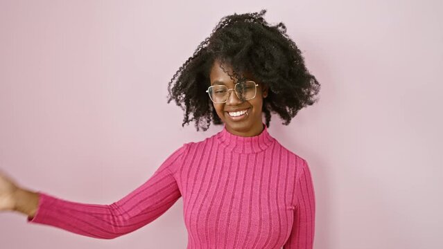 Joyful african american woman standing, saying a happy hello, waving in friendly welcome gesture while wearing glasses, smiling beautifully