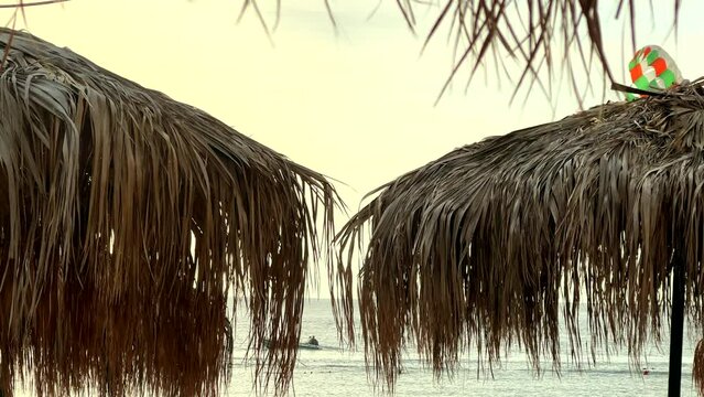 Tropical style sunshades and parasailing fun on beach holiday