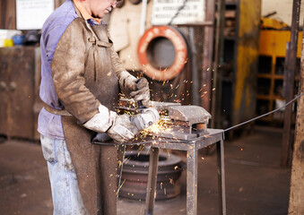 Blacksmith, man and grinder for metal with sparks, design or industry for metallurgy in factory....