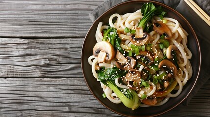 Asian vegetarian food udon noodles with baby bok choy, shiitake mushrooms, sesame and pepper close-up on a plate. horizontal top view - obrazy, fototapety, plakaty