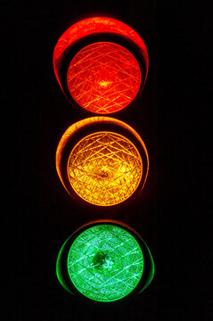 Alle drei Lichter einer Ampel beim Leuchten mit schwarzem Hintergrund