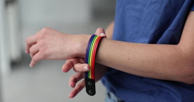 Woman puts an LGBT bracelet on hand