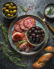 Geschmacksintensive Oliven mit eingelegten Peperoni und würziger Chorizo auf dunkler Granitplatte...