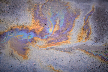 Oil rainbow gasoline spill on asphalt. Rainbow stains of oil and gasoline.