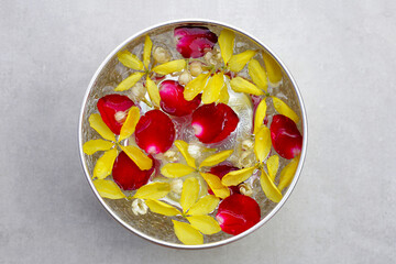 Water with jasmine flower golden shower and rose petal in silver bowl. Thai tradition, Songkran...