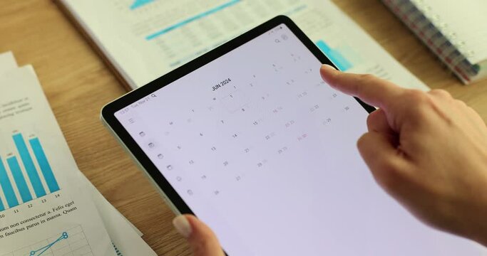 Woman uses a 2024 calendar application on tablet device