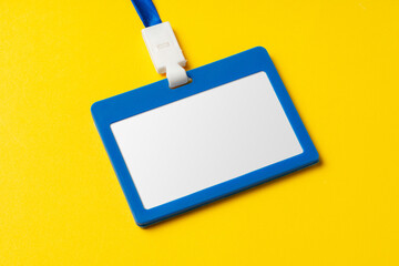 Blank nametag on a string on yellow background copy space