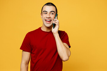 Young middle eastern man wear red t-shirt casual clothes talk speak on mobile cell phone conducting...